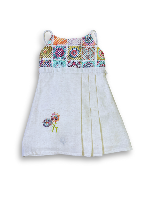 White girls' sleeveless dress with beige floral cutwork embroidery and a thin champagne-colored satin ribbon belt/sash.

Export to Sheets