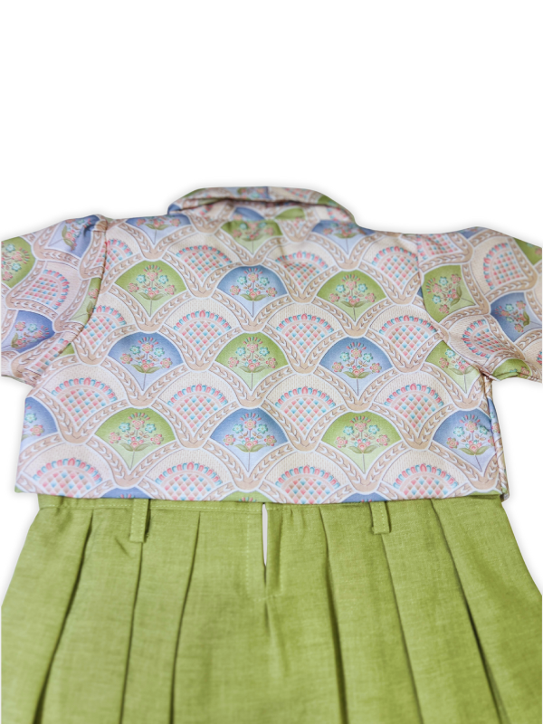 Girls' green pleated sleeveless dress paired with a detachable, short-sleeved bolero jacket featuring a light pastel fan-like print.

Export to Sheets