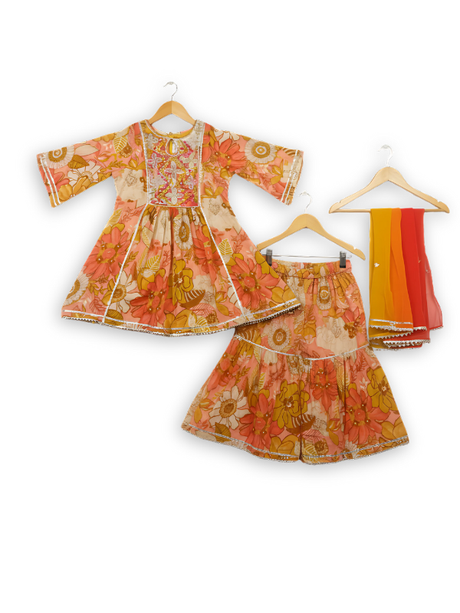 Girls' three-piece ethnic set featuring a yellow and orange floral print Kurti and Garara, and a vibrant yellow-to-pink ombre dupatta.