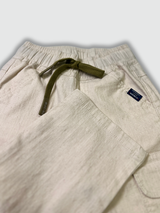 Boys' cream/light beige cargo pants with an elastic waist, green drawstring, and large flap cargo pockets.