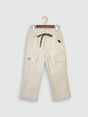 Boys' cream/light beige cargo pants with an elastic waist, green drawstring, and large flap cargo pockets.
