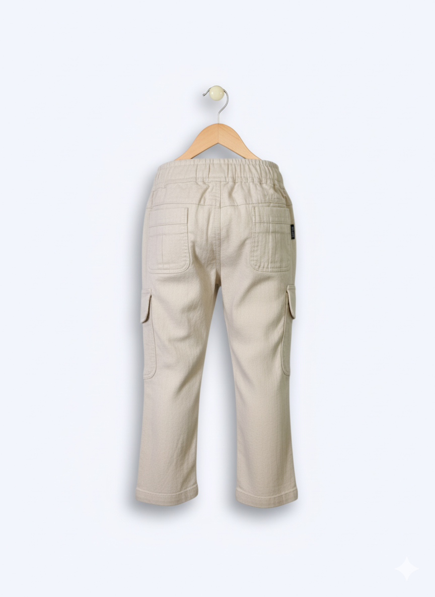 Boys' cream/light beige cargo pants with an elastic waist, green drawstring, and large flap cargo pockets.