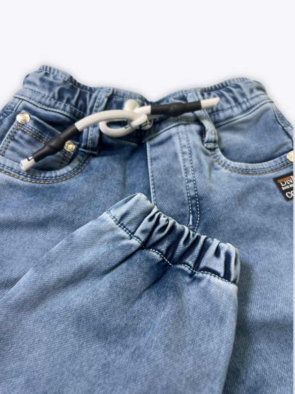 Boys' cream/light beige cargo pants with an elastic waist, green drawstring, and large flap cargo pockets.