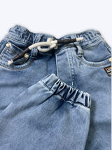 Boys' cream/light beige cargo pants with an elastic waist, green drawstring, and large flap cargo pockets.