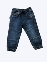 Close-up of boys' navy blue denim jogger pants with elastic waist, black drawstring, and elasticated ankle cuffs on a white background.