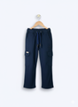 Boys' plain navy blue cargo pants made of soft fleece or knit material, hanging on a wooden hanger, showing the elastic waist and large side pockets.
