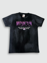 Black boys' short-sleeve T-shirt with a textured, blackout finish, featuring the word "MOUNTAIN" in a pink/purple gradient and a small motivational quote below