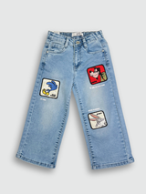 Light blue wash children's wide-leg denim jeans with large square cartoon character patches (including Road Runner and Bugs Bunny) on the front of the legs