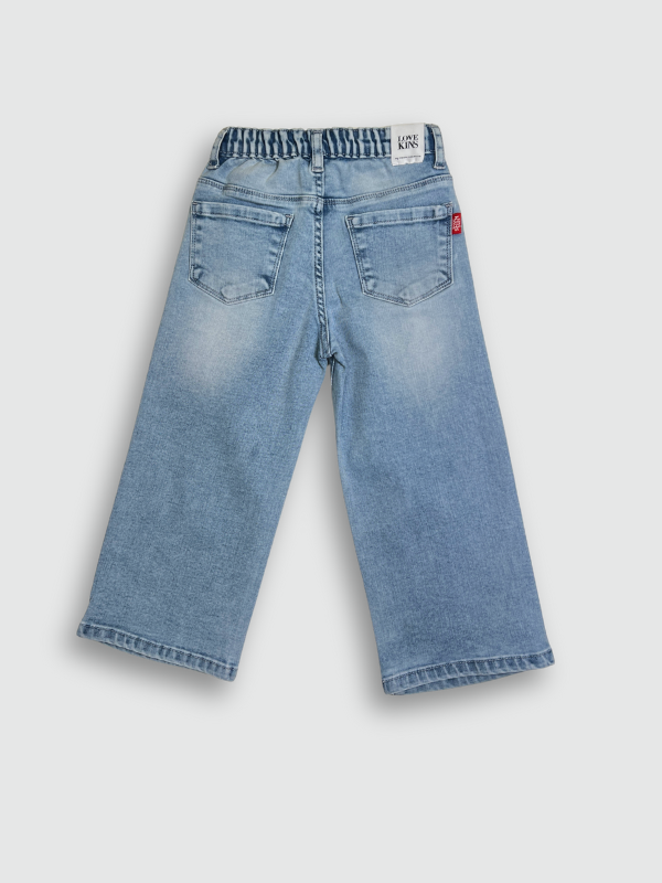 Light blue wash children's wide-leg denim jeans with large square cartoon character patches (including Road Runner and Bugs Bunny) on the front of the legs