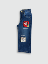 Dark blue wash children's wide-leg denim jeans with large square cartoon character patches (including Road Runner and Bugs Bunny) on the front of the legs