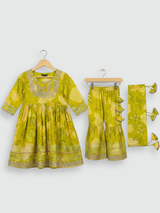 Full set laid flat: lime green kurta with gold embroidery and a floral print, matching tiered sharara pants, and a coordinating dupatta with green tassels.