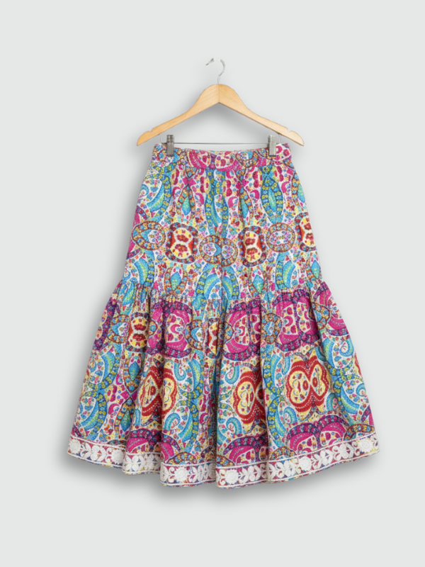 Full-length image of a young girl wearing a turquoise blue ethnic set with an embroidered peplum kurta, tiered sharara pants with a zig-zag print, and a white and blue ombre dupatta.q