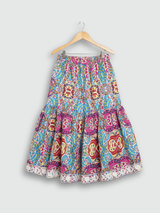 Full-length image of a young girl wearing a turquoise blue ethnic set with an embroidered peplum kurta, tiered sharara pants with a zig-zag print, and a white and blue ombre dupatta.q