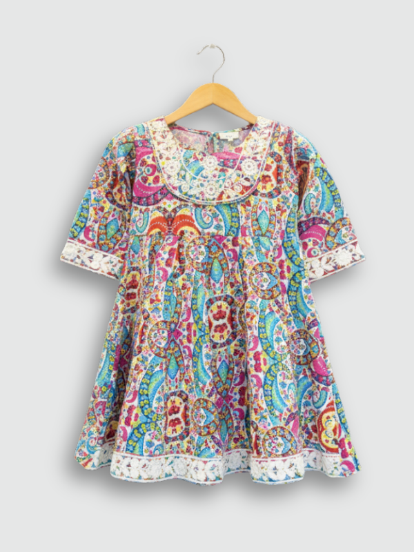 Full-length image of a young girl wearing a turquoise blue ethnic set with an embroidered peplum kurta, tiered sharara pants with a zig-zag print, and a white and blue ombre dupatta.q