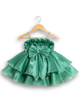 Teal green girls' sleeveless party frock on a hanger, featuring a shimmering pleated skirt and two large flower appliqués made from gold cord on the bodice.