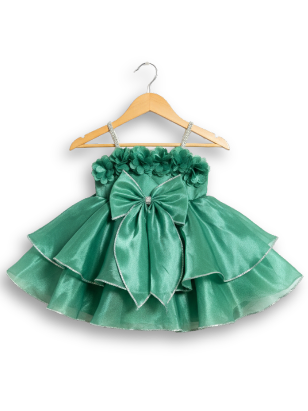 Teal green girls' sleeveless party frock on a hanger, featuring a shimmering pleated skirt and two large flower appliqués made from gold cord on the bodice.