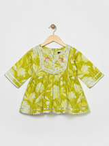 Full-length image of a young girl wearing a lime green and white floral-printed ethnic set with an embroidered peplum top, tiered gharara pants with a zig-zag print, and a white and green dupatta.