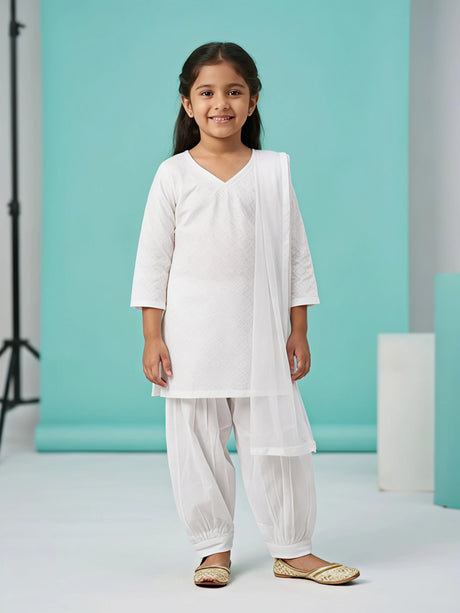 Young girl wearing a classic white textured short kurti with a pleated Patiala salwar and matching draped dupatta