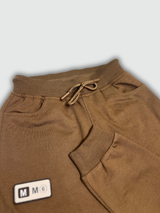Boys' plain brown fleece cargo jogger pants with elastic drawstring waist and cuffed ankles, hanging on a wooden hanger.