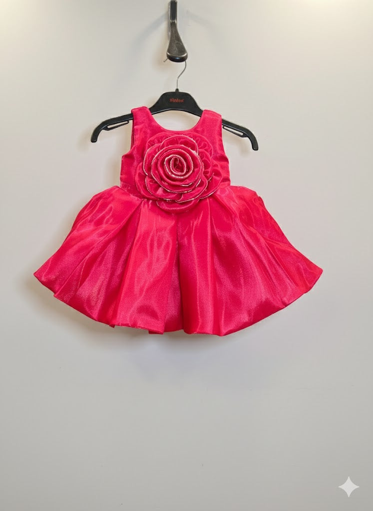 Sleeveless girls' party frock in a vibrant rani pink, featuring a large, layered 3D rose appliqué on the bodice.